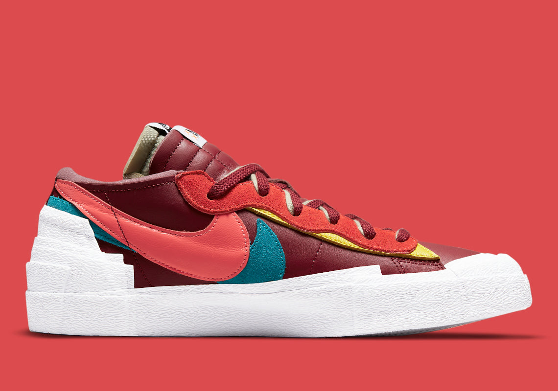 Nike Blazer Low sacai KAWS Red – sneaker rouge en cuir avec double Swoosh multicolore et logo XX de KAWS, vue de coter