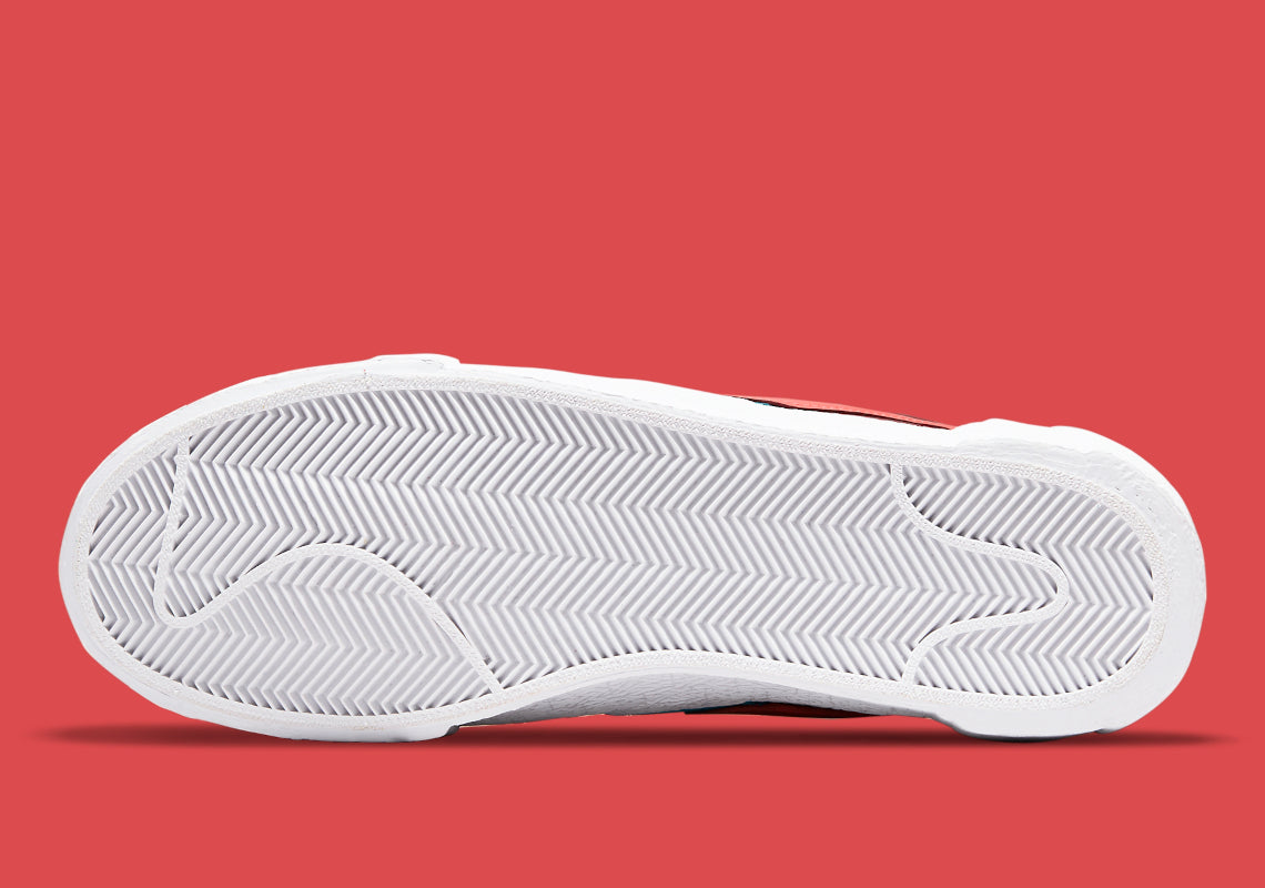 Nike Blazer Low sacai KAWS Red – sneaker rouge en cuir avec double Swoosh multicolore et logo XX de KAWS, vue de la semelle