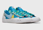 Nike Blazer Low sacai KAWS Neptune Blue – sneaker bleue en cuir avec double Swoosh multicolore et logo XX de KAWS, vue de profil