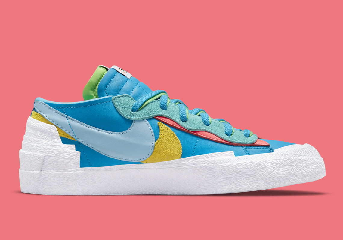 Nike Blazer Low sacai KAWS Neptune Blue – sneaker bleue en cuir avec double Swoosh multicolore et logo XX de KAWS, vue de coter