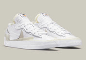 Nike Blazer Low sacai White Patent Leather – sneaker en cuir verni blanc avec double Swoosh et semelle empilée, vue de profil