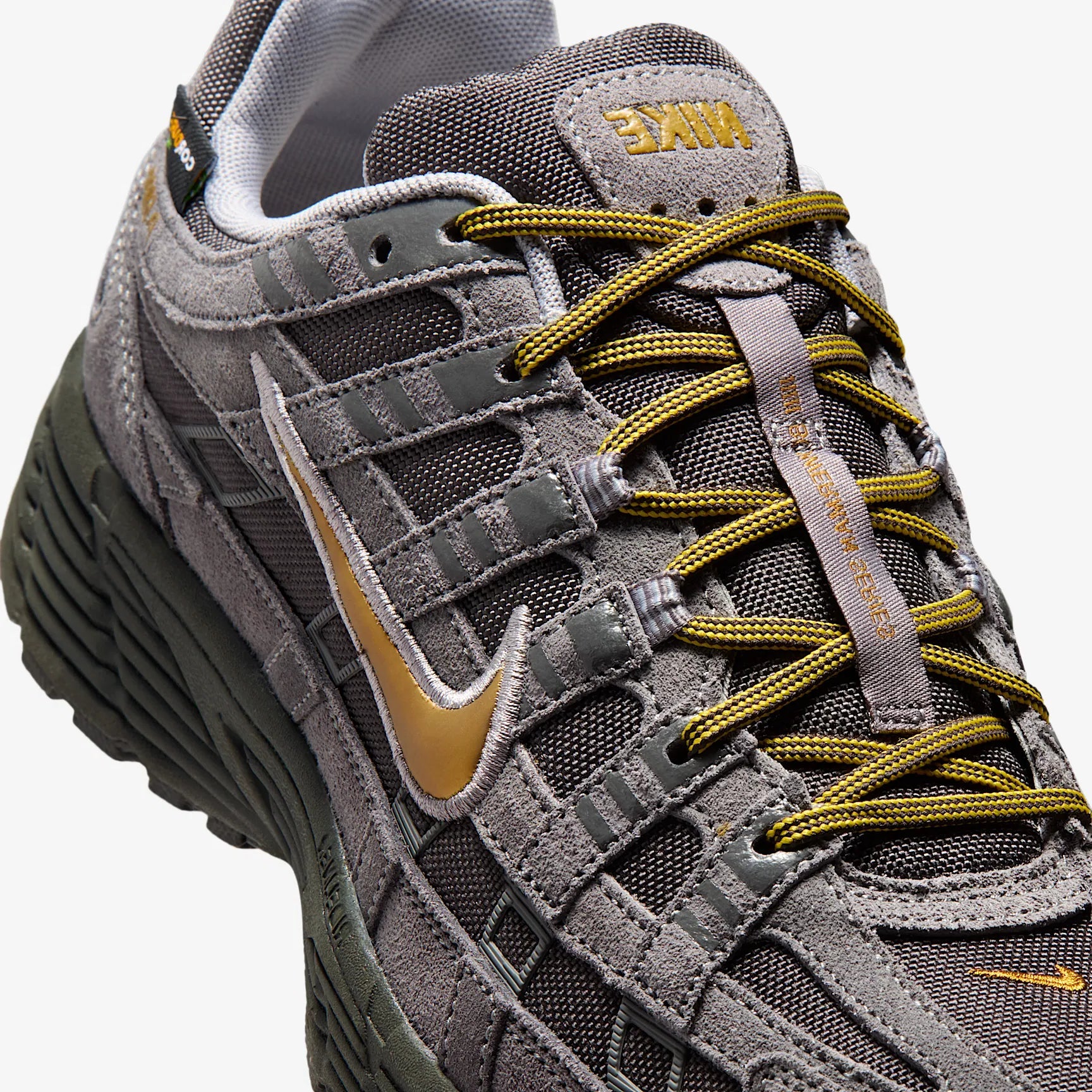 Vue zoomée sur les détails latéraux de la Nike P-6000 Premium Cordura Medium Ash Golden Hops en tons gris et brun, avec empeigne en cuir, daim et CORDURA® et semelle en mousse.