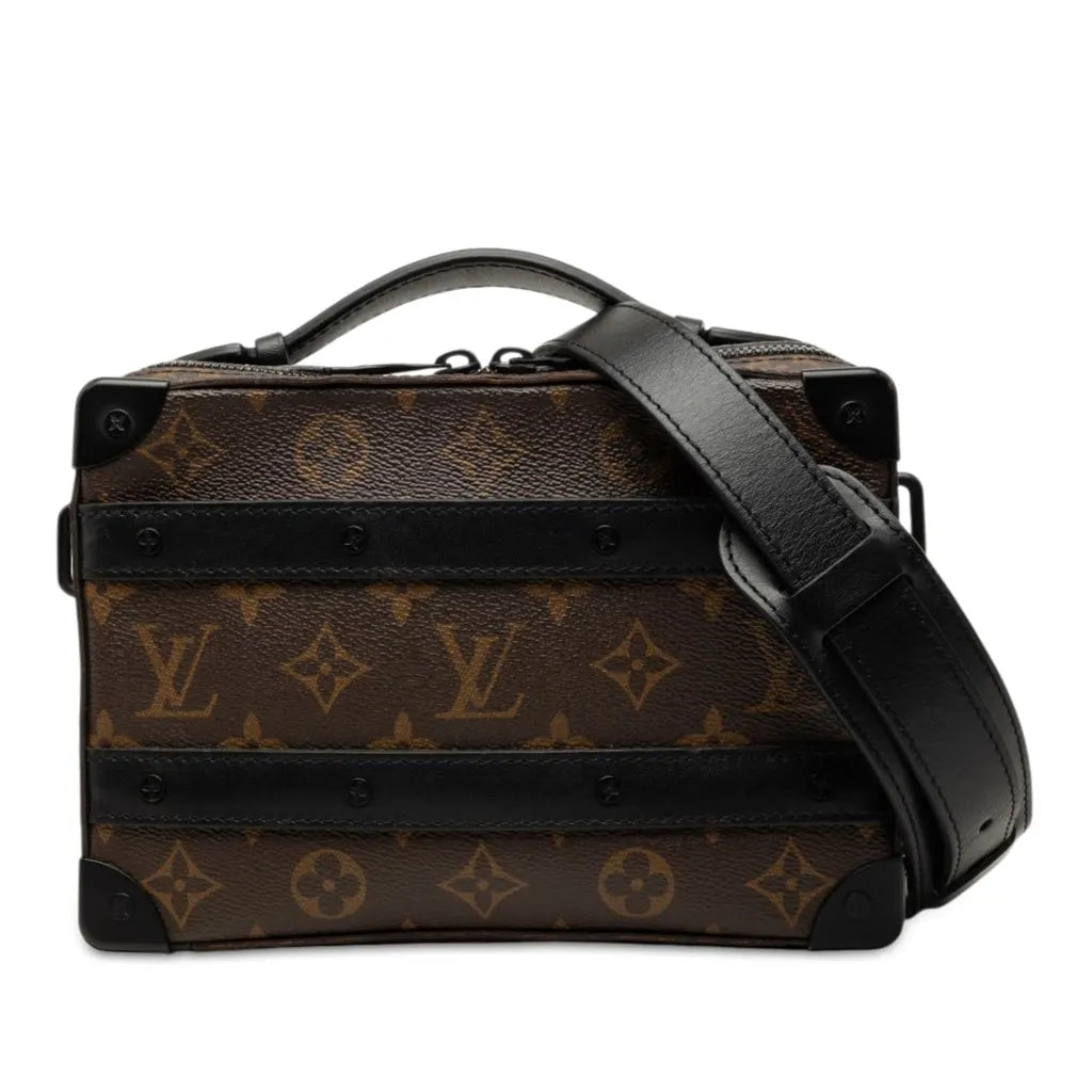 Louis Vuitton Handle Soft Trunk Monogram Macassar Brown, sac Louis Vuitton rectangulaire en toile Monogram marron avec finitions noires, poignée supérieure et bandoulière.