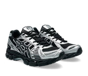 ASICS Gel-Kayano 12.1 Black Pure Silver en mesh noir avec détails argentés métallisés, amorti GEL et silhouette rétro-running technique.