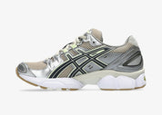 Sneaker ASICS Gel-Nimbus 9 Feather Grey en mesh gris clair avec amorti GEL, détails techniques et silhouette rétro-running inspirée des années 2000.