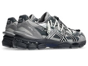 Image de la ASICS GEL-CUMULUS 16 TG Grey Black/Pure Silver, sneaker gris foncé et noir avec accents argent métallisé, tige en mesh et surpiqûres techniques, semelle avec amorti GEL™ visible. Vue de 3/4 arrière. 