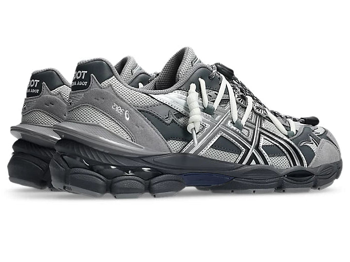 Image de la ASICS GEL-CUMULUS 16 TG Grey Black/Pure Silver, sneaker gris foncé et noir avec accents argent métallisé, tige en mesh et surpiqûres techniques, semelle avec amorti GEL™ visible. Vue de 3/4 arrière. 