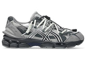 Image de la ASICS GEL-CUMULUS 16 TG Grey Black/Pure Silver, sneaker gris foncé et noir avec accents argent métallisé, tige en mesh et surpiqûres techniques, semelle avec amorti GEL™ visible. Vue de profil. 