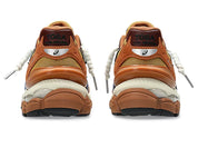 Image de la ASICS GEL-CUMULUS 16 × TOGA “Brown Blue Pure Silver”, sneaker marron terre et bleu vif avec détails argentés métallisés, tige mesh et superpositions synthétiques, amorti GEL visible, collaboration ASICS × TOGA. Vue de derrière. 