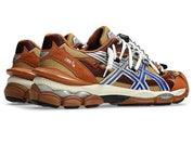 Image de la ASICS GEL-CUMULUS 16 × TOGA “Brown Blue Pure Silver”, sneaker marron terre et bleu vif avec détails argentés métallisés, tige mesh et superpositions synthétiques, amorti GEL visible, collaboration ASICS × TOGA. Vue de 3/4 arrière. 