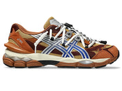 Image de la ASICS GEL-CUMULUS 16 × TOGA “Brown Blue Pure Silver”, sneaker marron terre et bleu vif avec détails argentés métallisés, tige mesh et superpositions synthétiques, amorti GEL visible, collaboration ASICS × TOGA. Vue de profil. 
