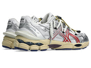 Image de la ASICS GEL-CUMULUS 16 × TOGA White/Red Pure Silver, sneaker blanche, accents rouges et détails argentés, tige en mesh technique, double laçage, système amorti GEL visible. Vue de 3/4 arrière. 