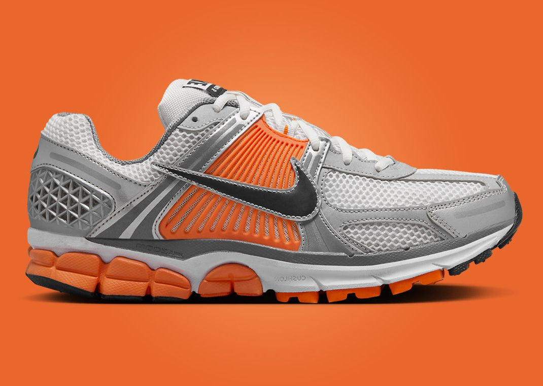 Nike Zoom Vomero 5 en mesh respirant avec renforts synthétiques, coloris Platinum Tint et accents Safety Orange, amorti Zoom Air réactif. vue de profil