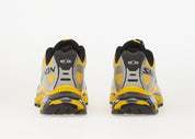 Salomon XT-4 OG Silver Black Lemon avec tige en maille respirante argentée, renforts noirs, détails Lemon, système Quicklace™ et semelle Contagrip® à crampons vue de derrière. 