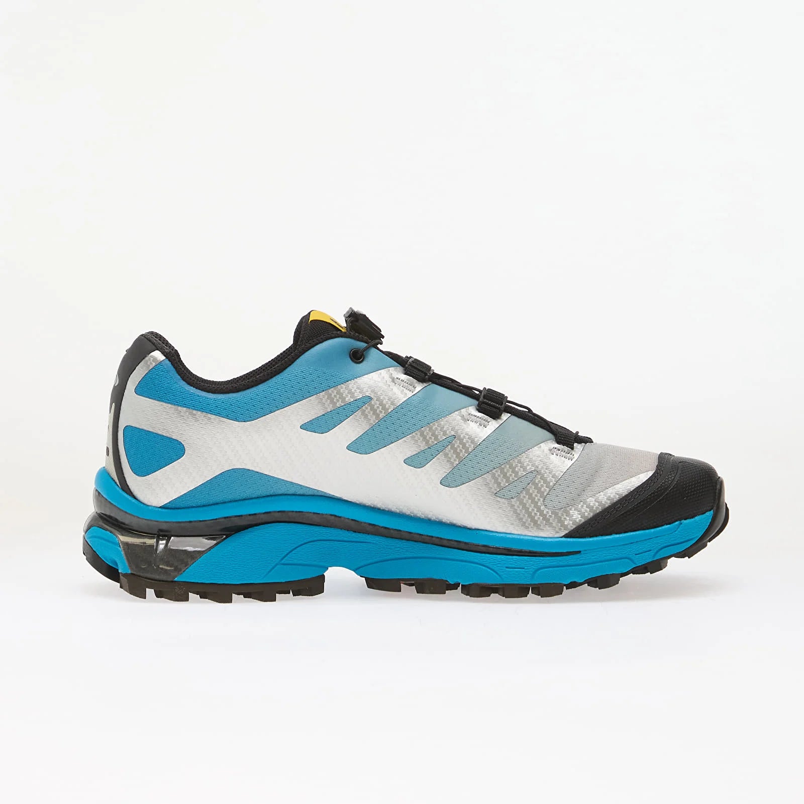 Salomon XT-4 OG Silver Black Transcend Blue avec tige en maille respirante argentée, renforts noirs, détails Transcend Blue, système Quicklace™ et semelle Contagrip® à crampons.