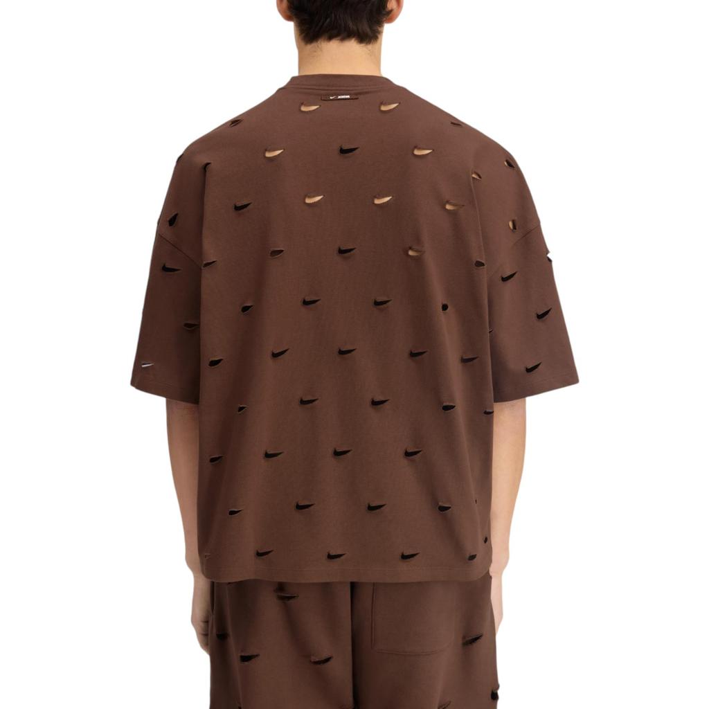 Jacquemus x Nike Le Swoosh T-shirt Brown à manches courtes, coloris brun, col rond et détail Swoosh Nike revisité dans l'univers minimaliste de Jacquemus porté vu de dos. 