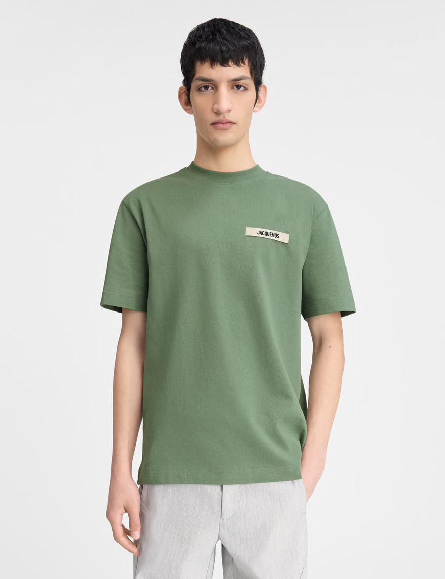 Jacquemus Le T-shirt Gros Grain Light Green, tee-shirt en coton vert clair premium, avec bande Gros Grain ton sur ton sur la poitrine, coupe ample wide cut, col rond en bord-côte et finitions renforcées.