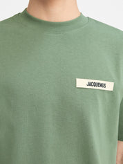 Jacquemus Le T-shirt Gros Grain Light Green, tee-shirt en coton vert clair premium, avec bande Gros Grain ton sur ton sur la poitrine, coupe ample wide cut, col rond en bord-côte et finitions renforcées.