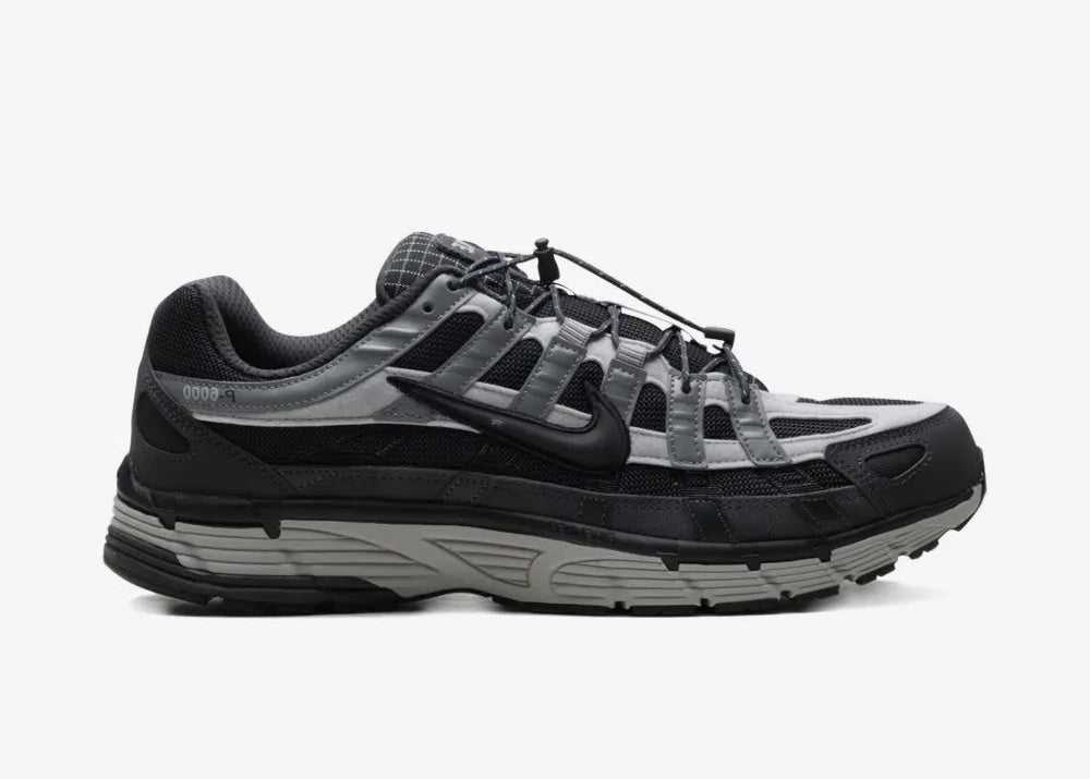 Nike P-6000 Anthracite Smoke Grey grise et noire avec tige textile, superpositions en cuir, Swoosh réfléchissant et semelle rétro-running.