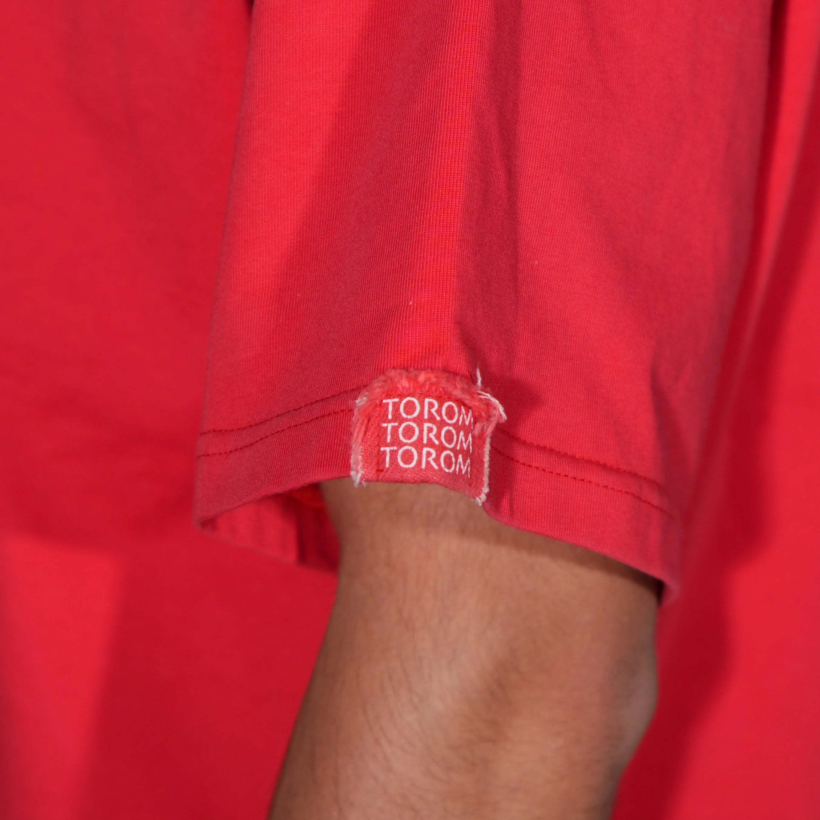 tee shirt torom rouge , zoom sur la manche 