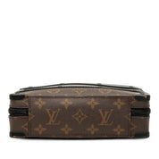 Louis Vuitton Handle Soft Trunk Monogram Macassar Brown, sac Louis Vuitton rectangulaire en toile Monogram marron avec finitions noires, poignée supérieure et bandoulière.