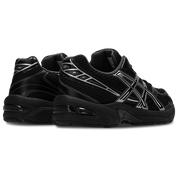 Image de l’ASICS GEL-1130 Black/Pure Silver – sneaker noire en mesh et cuir synthétique avec détails argentés métallisés, insert GEL® visible au talon. (vue de 3/4 arrière)