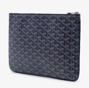 Goyard Senat Pouch MM Navy Blue, pochette en toile Goyardine bleu marine avec motif chevrons, détails en cuir et fermeture zippée.