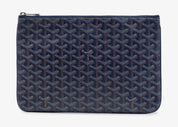Goyard Senat Pouch MM Navy Blue, pochette en toile Goyardine bleu marine avec motif chevrons, détails en cuir et fermeture zippée.