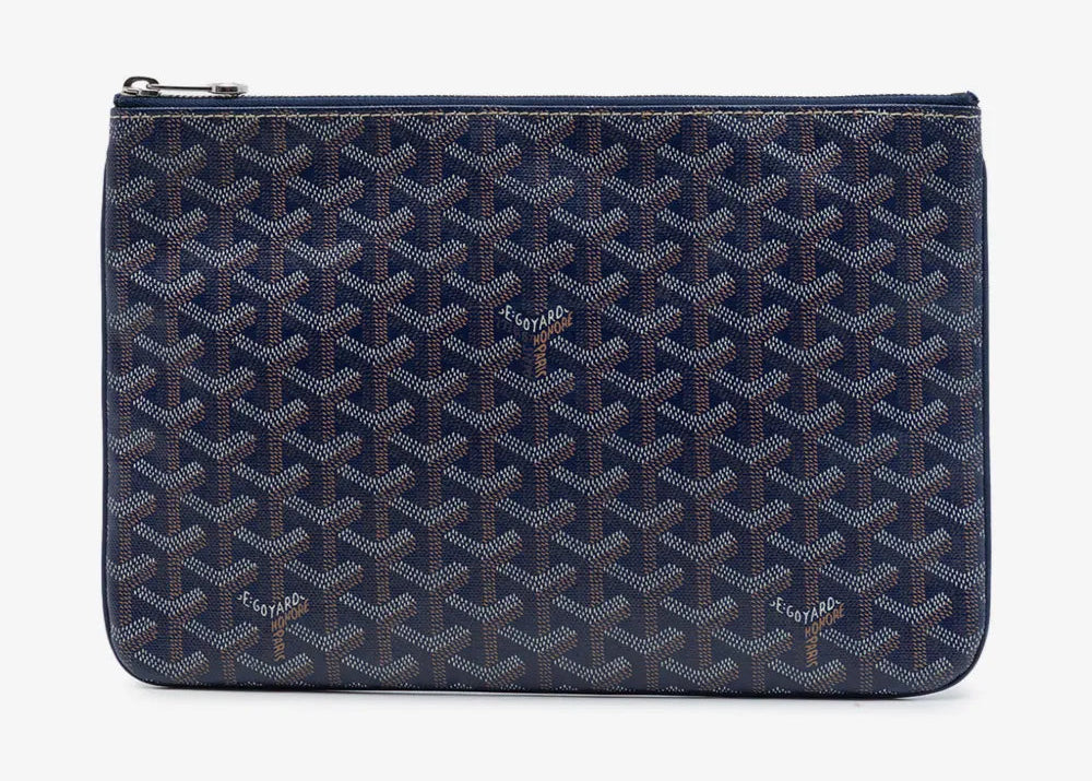 Goyard Senat Pouch MM Navy Blue, pochette en toile Goyardine bleu marine avec motif chevrons, détails en cuir et fermeture zippée.