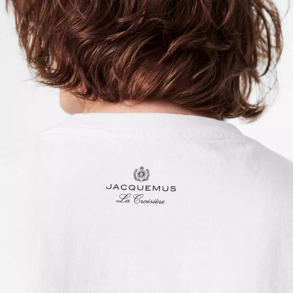 TEE SHIRT JACQUEMUS BLANC A LOGO IMPRIME BLANC SUR L'AVANT DU TEE-SHIRT AVEC UN DESSIN DE PALMIER SUR LA PLAGE