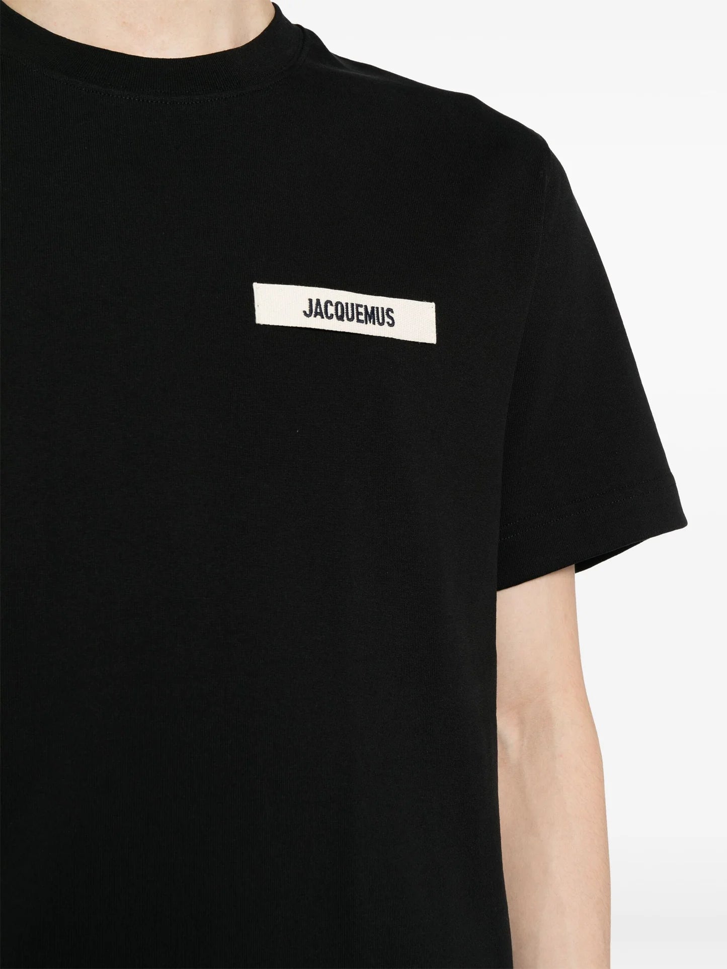 Jacquemus Le T-shirt Gros Grain Black, tee-shirt en coton noir premium, avec bande Gros Grain ton sur ton sur la poitrine, coupe ample wide cut, col rond en bord-côte et coutures renforcées.