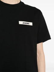 Jacquemus Le T-shirt Gros Grain Black, tee-shirt en coton noir premium, avec bande Gros Grain ton sur ton sur la poitrine, coupe ample wide cut, col rond en bord-côte et coutures renforcées.