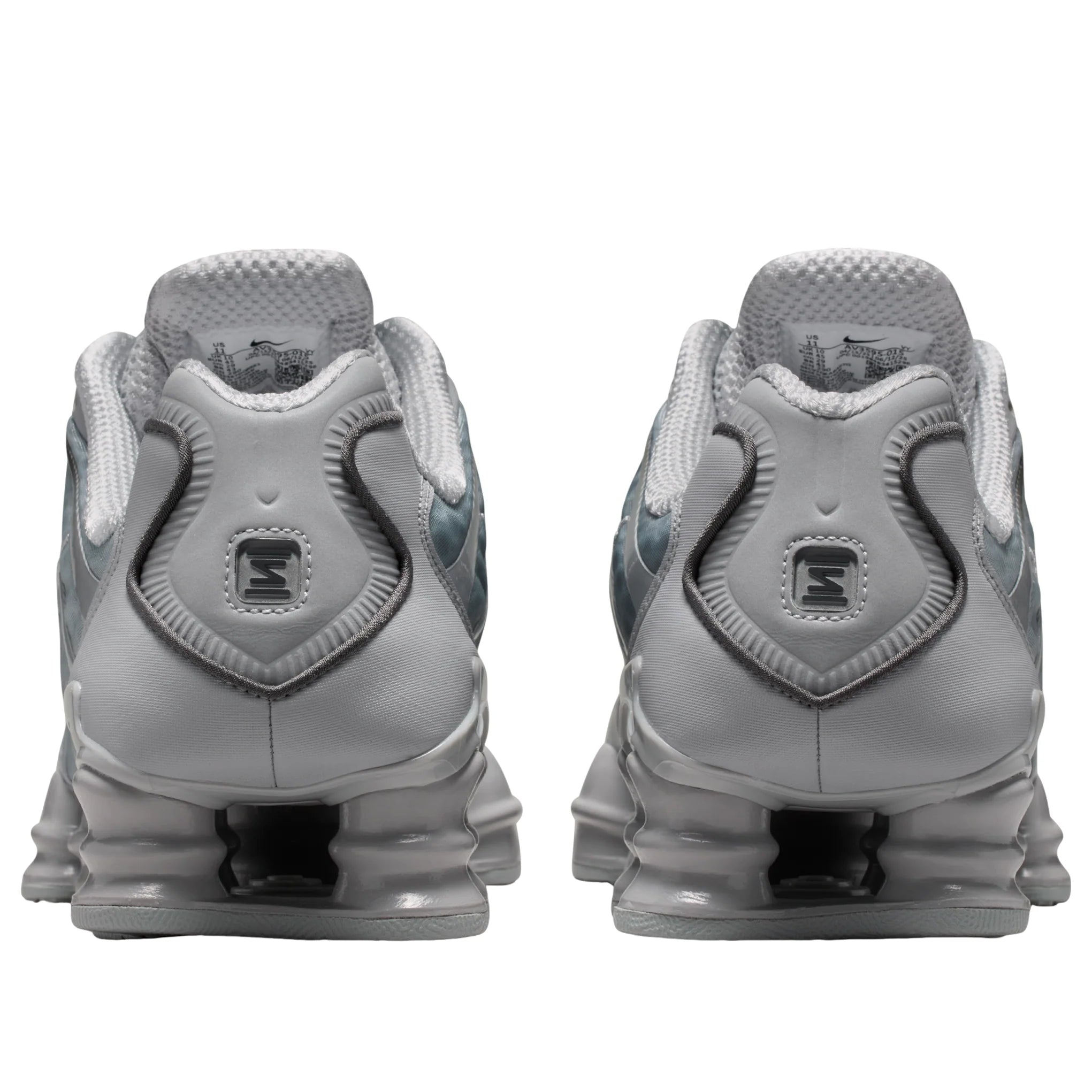 Nike Shox TL Wolf Grey Iron Grey avec tige en mesh respirant, renforts synthétiques Wolf Grey et Iron Grey et semelle Nike Shox intégrale offrant amorti et stabilité vue de derrière. 