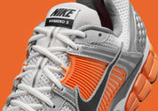 Nike Zoom Vomero 5 en mesh respirant avec renforts synthétiques, coloris Platinum Tint et accents Safety Orange, amorti Zoom Air réactif. zoom avant de la chaussure