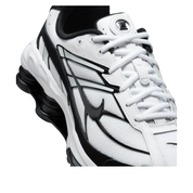 Vue zoomée sur les détails latéraux de la Nike Shox Ride 2 White Black avec tige en mesh respirant blanc, empiècements synthétiques noirs, amorti Nike Shox au talon et semelle extérieure en caoutchouc.