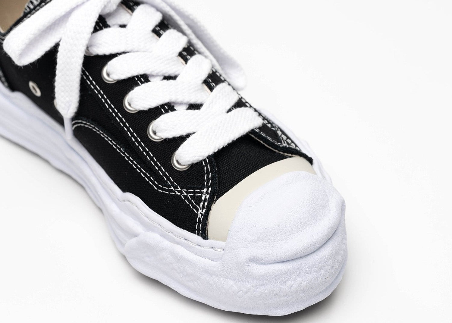 Découvrez la Maison Mihara Yasuhiro Hank OG Sole Canvas Low Black, une sneaker en toile noire avec semelle OG Sole sculptée en caoutchouc et silhouette basse au design expérimental.