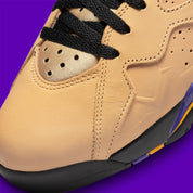 Vue zoomée sur la toe box de la Air Jordan 7 Retro SE Vachetta Tan DZ4729-200 en beige Vachetta Tan avec détails noirs, violets et orange inspirés de l’univers Afrobeats.