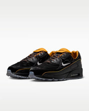 Sneaker Nike Air Max 90 Dark Cinder Mercurial Vapor 1 marron foncé en mesh technique avec semelle Air visible et détails football rétro.