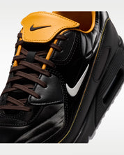 Sneaker Nike Air Max 90 Dark Cinder Mercurial Vapor 1 marron foncé en mesh technique avec semelle Air visible et détails football rétro.