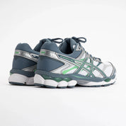 Sneaker ASICS Gel-Cumulus 16 White Ironclad en mesh blanc avec détails gris métallisés, amorti GEL et silhouette rétro-running technique.