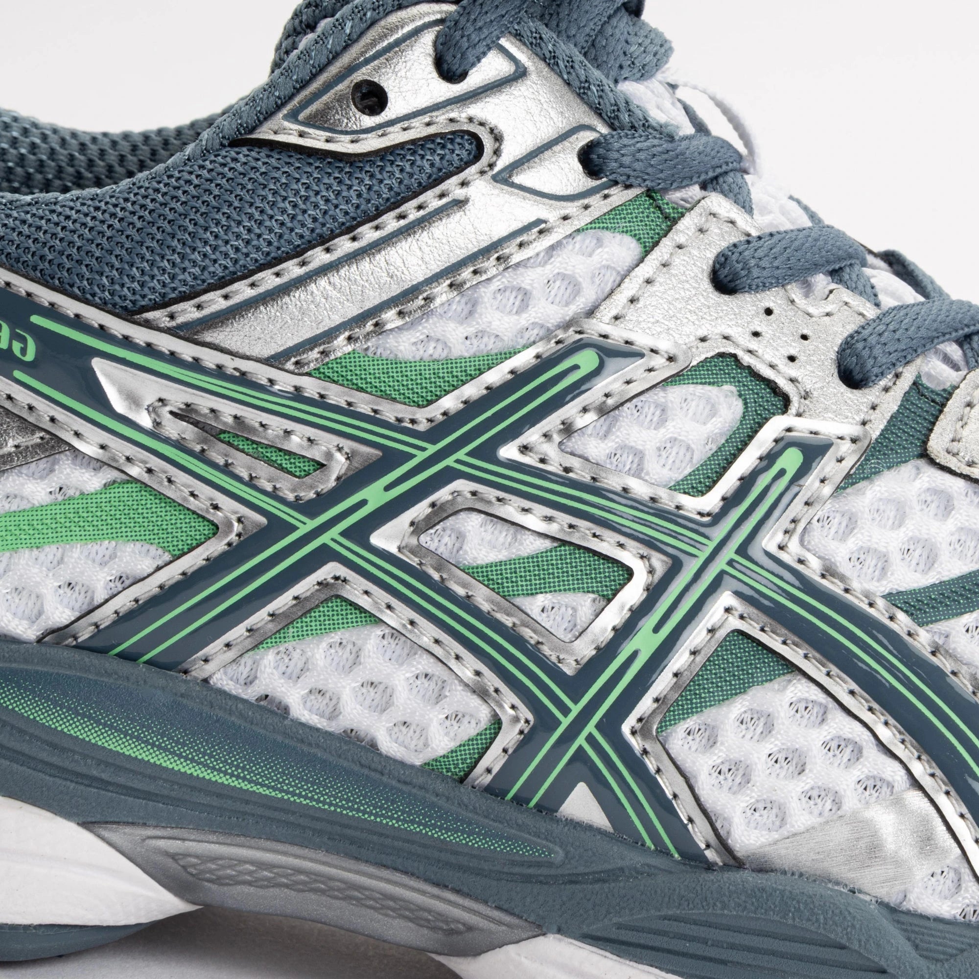 Sneaker ASICS Gel-Cumulus 16 White Ironclad en mesh blanc avec détails gris métallisés, amorti GEL et silhouette rétro-running technique.