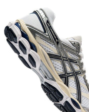 ASICS Gel-Cumulus 16 White Midnight en mesh blanc avec détails bleu nuit, amorti GEL et silhouette rétro-running technique.