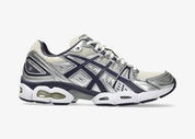 ASICS Gel-Nimbus 9 en mesh Oatmeal avec détails Indigo Fog et amorti GEL visible.