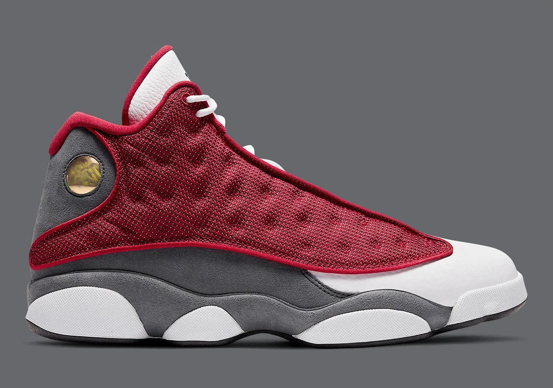 Air Jordan 13 Retro Gym Red Flint Grey DJ5982-600 en cuir blanc, Durabuck Flint Grey et mesh réfléchissant Gym Red.