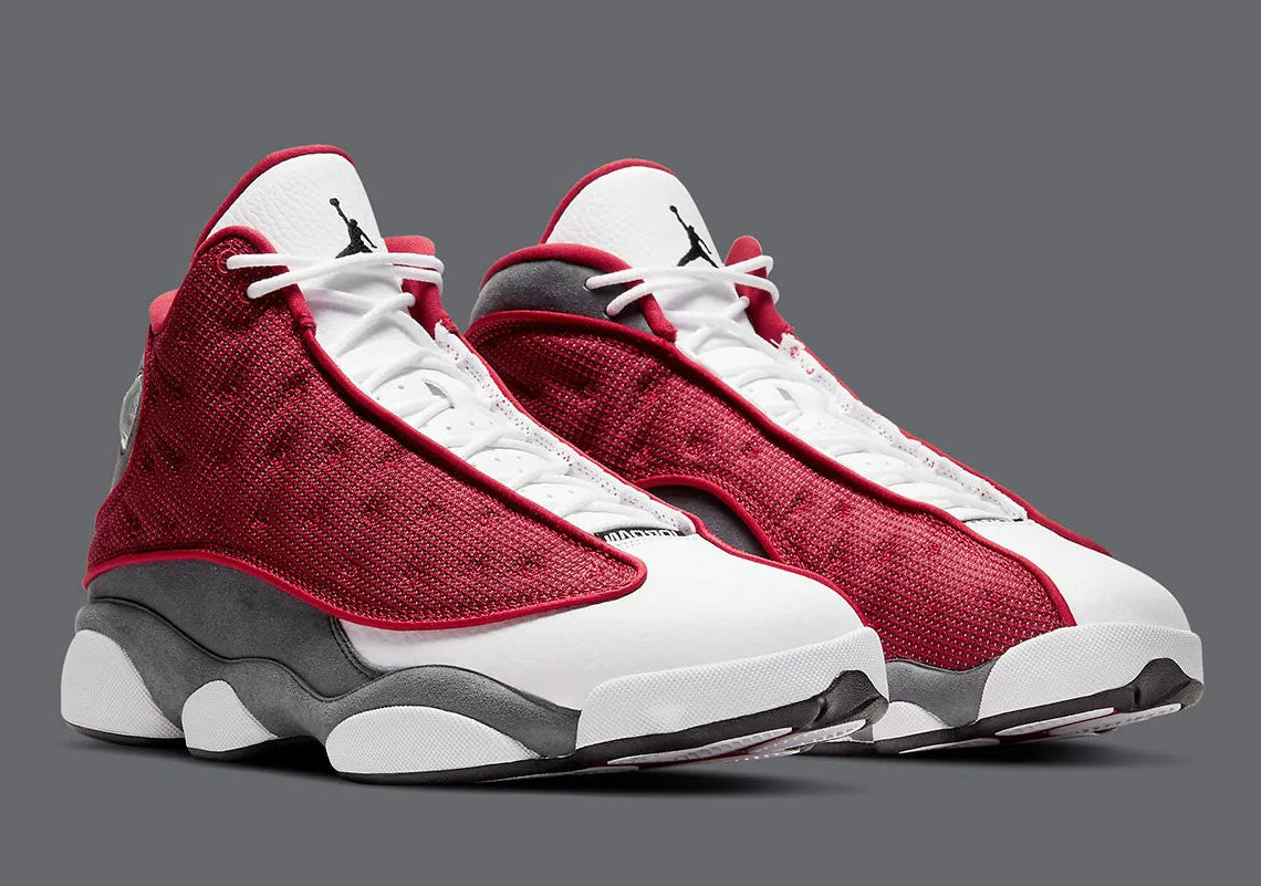 Air Jordan 13 Retro Gym Red Flint Grey DJ5982-600 en cuir blanc, Durabuck Flint Grey et mesh réfléchissant Gym Red.
