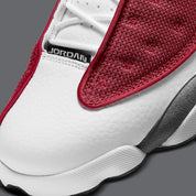 Air Jordan 13 Retro Gym Red Flint Grey DJ5982-600 en cuir blanc, Durabuck Flint Grey et mesh réfléchissant Gym Red.