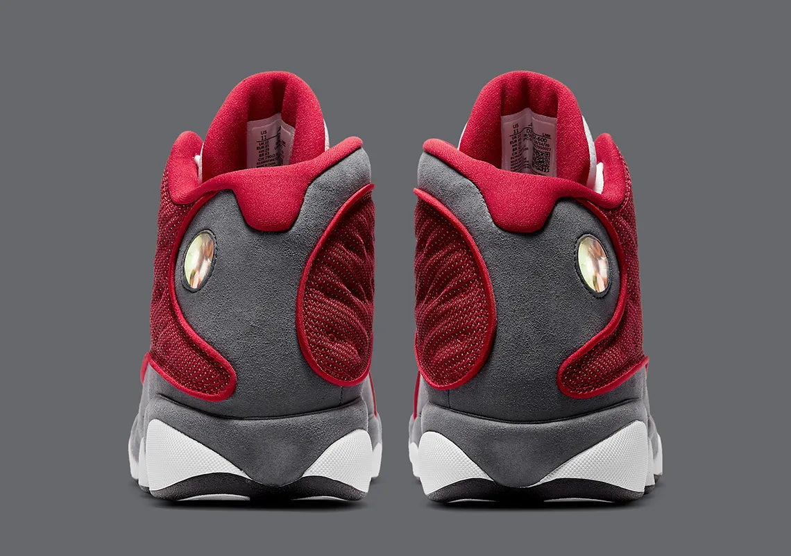 Air Jordan 13 Retro Gym Red Flint Grey DJ5982-600 en cuir blanc, Durabuck Flint Grey et mesh réfléchissant Gym Red.