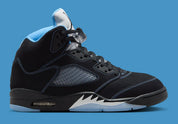 Air Jordan 5 Retro Black University Blue 2026 en nubuck noir avec accents bleus, languette réfléchissante et unité Air visible au talon.