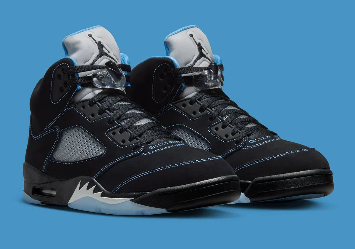 Air Jordan 5 Retro Black University Blue 2026 en nubuck noir avec accents bleus, languette réfléchissante et unité Air visible au talon.