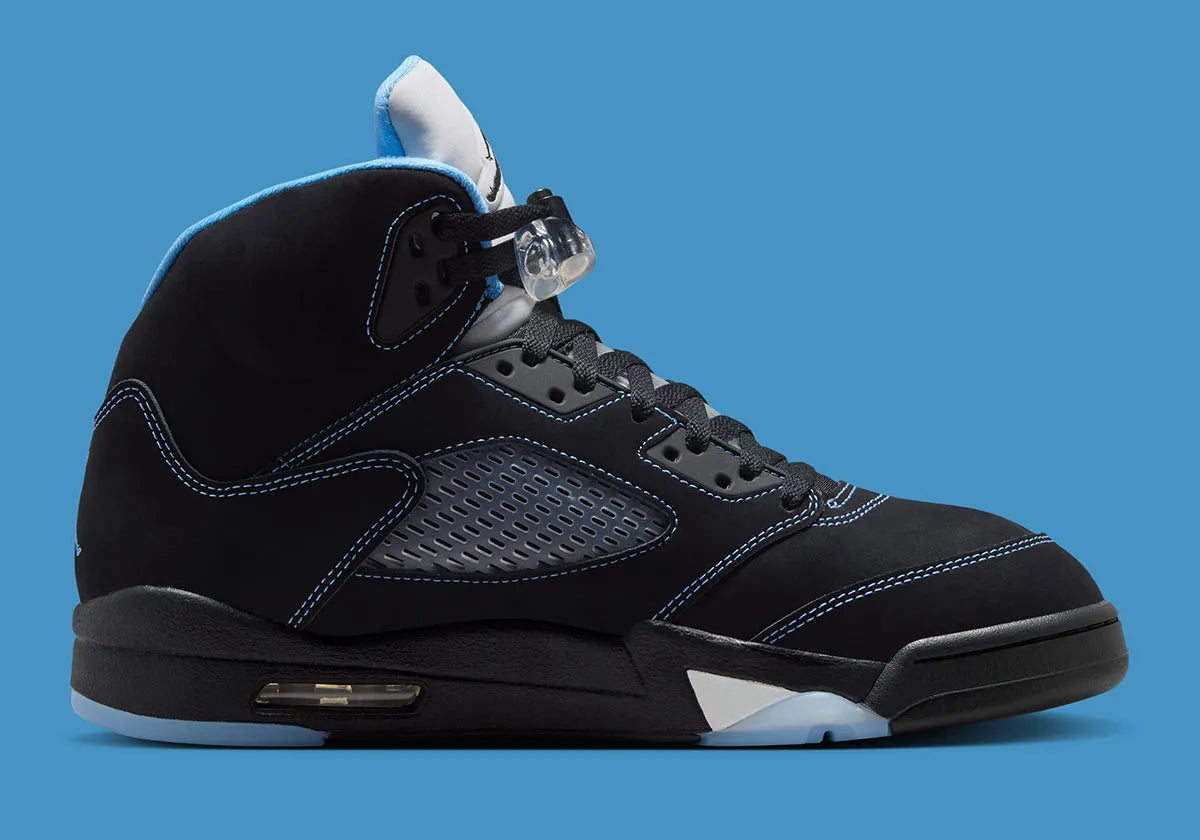 Air Jordan 5 Retro Black University Blue 2026 en nubuck noir avec accents bleus, languette réfléchissante et unité Air visible au talon.